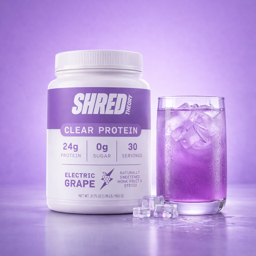 Shred Theory Clear Protein Electric Grape tub with liquid in a glass cup next to it